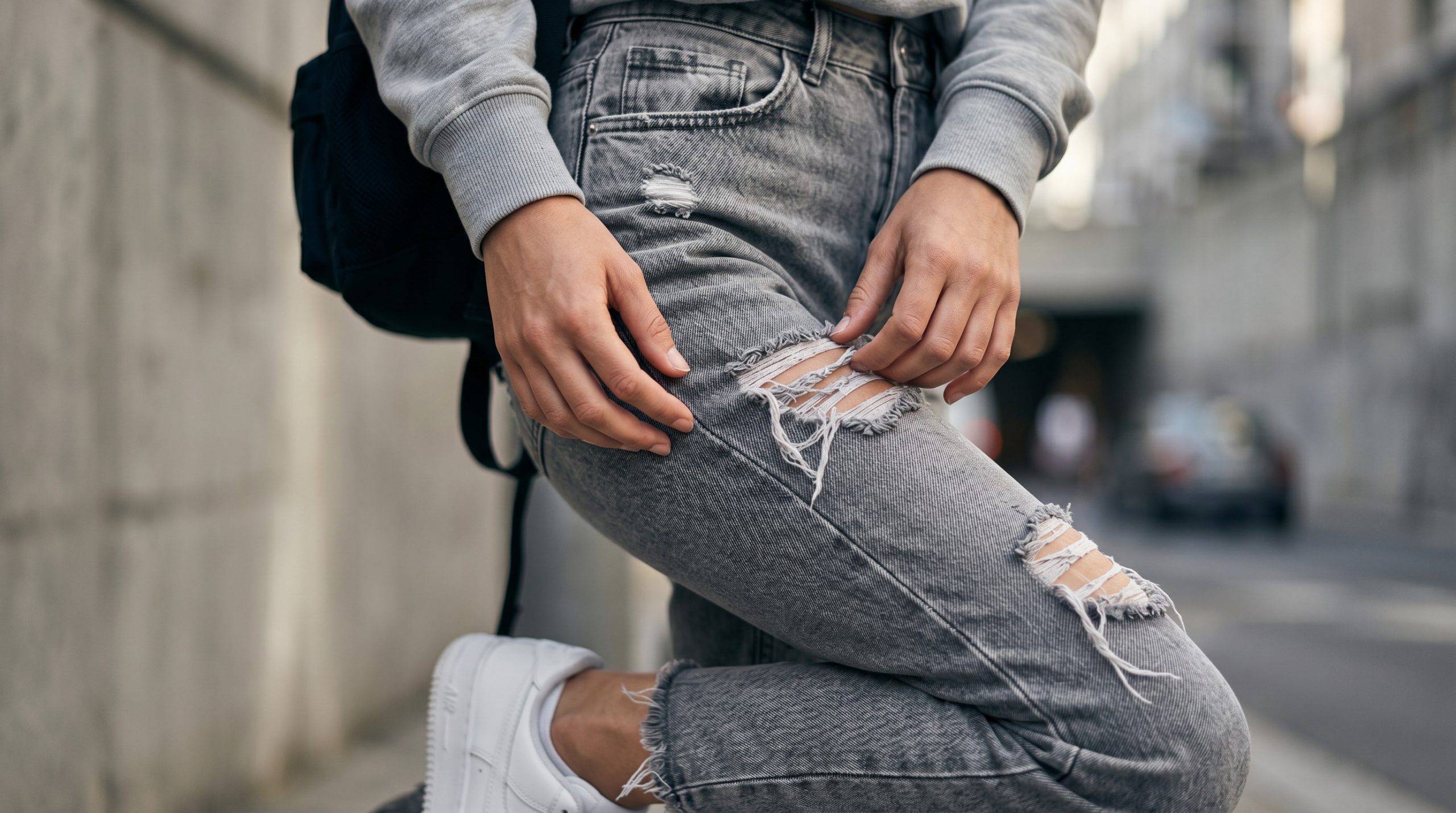 Крупний план текстурних літніх рваних джинсів 2026, що демонструють модні потертості та обробку тканини.